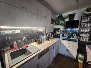 a kitchen with white cabinets and a sink at Ubytování Srdcovka in Vrchlabí