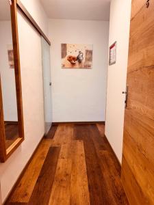 an empty hallway with a door and wooden floors at Enns Sleep Self Check In in Enns