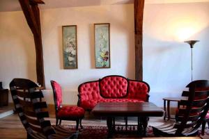 a living room with a red couch and chairs at L'ancien Tribunal in Tonnerre