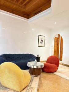 ein Wohnzimmer mit einem blauen Sofa und 2 Stühlen in der Unterkunft Appart villa de luxe avec 5 piscines in Marrakesch
