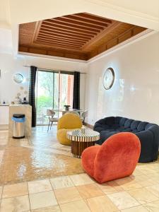 ein Wohnzimmer mit Sofas, Stühlen und einem Tisch in der Unterkunft Appart villa de luxe avec 5 piscines in Marrakesch