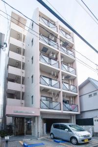 ein Gebäude mit einem davor geparkten Auto in der Unterkunft Escort Haruyoshi in Fukuoka
