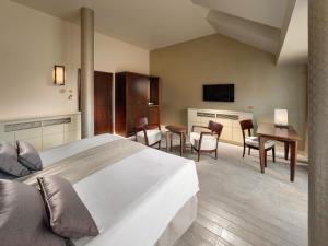 a hotel room with a bed and a table and chairs at Mamaison Le Regina Boutique Hotel in Warsaw