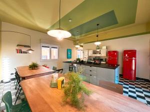a kitchen with two wooden tables and a red refrigerator at Ostello Bello Bologna in Bologna
