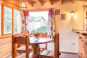 a dining room with a table and a window at Cocos Cura Casas de montaña in San Carlos de Bariloche