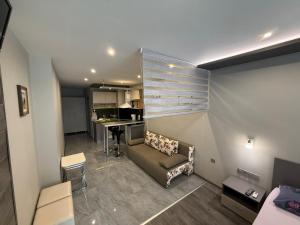 a small living room with a couch and a kitchen at Апартаменти в сърцето на парка in Sandanski
