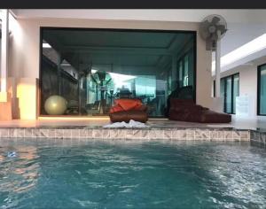 a house with a swimming pool in front of a building at P&S Residence in Ban Khlong Rang