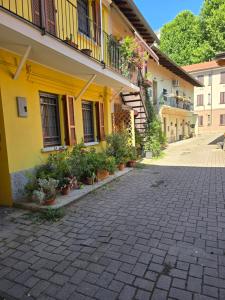 a yellow building with potted plants in front of it at La Hora Feliz - Metro Sesto Rondo' in Sesto San Giovanni +1 photo