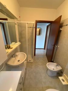 un bagno con due lavandini, una doccia e un WC di La Quiete 30 Lake view apartment by Gardadomusmea a Tremosine Sul Garda