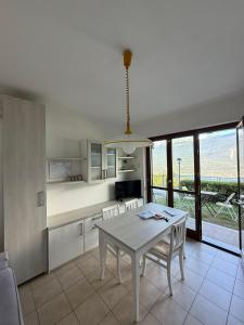 una cucina e una sala da pranzo con tavolo e sedie di La Quiete 30 Lake view apartment by Gardadomusmea a Tremosine Sul Garda