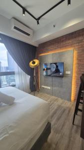 a bedroom with a bed and a tv on a brick wall at Agile Pavillion TRX Luxury Suited Kuala Lumpur Good View in Kuala Lumpur +20 photos