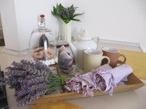 a tray with purple flowers and mugs on a counter at Zd City Apartment in Zadar