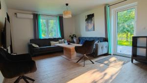 a living room with a couch and a table and chairs at Domki w Winnicy - Świętokrzyska Winnica Knapów in Krzczonowice
