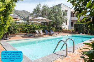 una piscina con dos sillas y una sombrilla en Villa Costanza, en Mondello