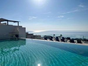 una piscina in cima a un edificio con sedie di Luxury House with Private Pool, Jacuzzi and Wellness Spa a Torrox Costa