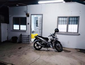 a motorcycle parked next to a wall in a garage at BUDGET Homestay RumahTamu TELIPOT Kota Bharu in Kota Bharu +1 photo