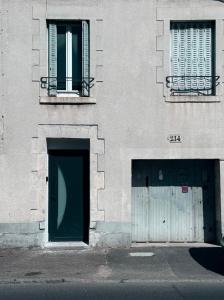a building with two doors and two windows on it at Chaleureux Studio Tout Confort in Orléans