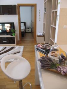 a living room with a counter and a white chair at Zd City Apartment in Zadar