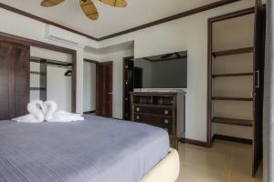 a bedroom with a bed with a dresser and a tv at Diamante del Sol 303S- 3rd Floor Ocean View in Jacó