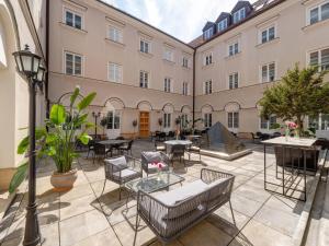 a courtyard with tables and chairs in a building at Mamaison Le Regina Boutique Hotel in Warsaw