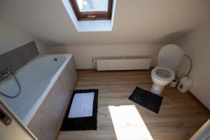 a bathroom with a bath tub and a toilet at Villa Vintage Room B 107 in Tomášikovo