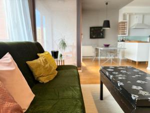 普里什蒂纳Artist's Apartment in Prishtina的客厅里有一张绿色的沙发和一张桌子 更多19张照片