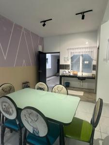 a dining room with a green table and chairs at Adik Aisyah homestay cameron quintet A3-7-3A in Tanah Rata