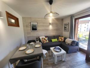 un salon avec un canapé et une table dans l'établissement Studio moderne à Montgenèvre avec garage intégré - FR-1-266-245, à Montgenèvre