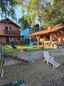 a yard with a white chair and a house at Vila Marina in Kovin
