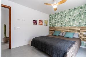 une chambre avec un lit et un ventilateur de plafond dans l'établissement Stylish and central flat - Puerto de la Cruz, à Puerto de la Cruz