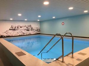 a large swimming pool with a painting on the wall at Morgins, studio avec balcon in Morgins