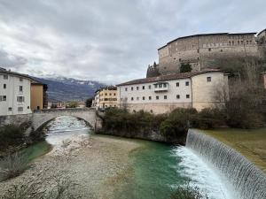 a bridge over a river in front of a castle at Apartments via Roma in Rovereto