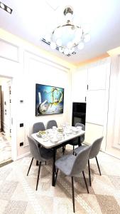 une salle à manger avec une table, des chaises et un lustre dans l'établissement Nest One Tower, à Tachkent