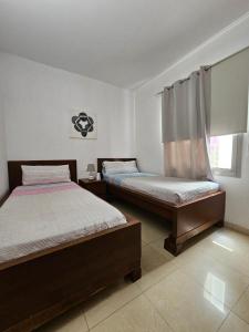 una camera da letto con due letti e una finestra di Residencial Sol Suite a Telde