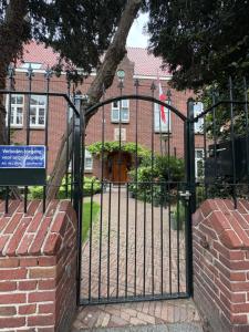 a black gate in front of a brick building at Bommelsteijn Lodge in Dordrecht
