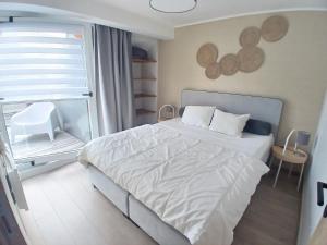 维尔雅尔姆Bee Tree Appartement的一间卧室，有一张白色的床和一扇窗户