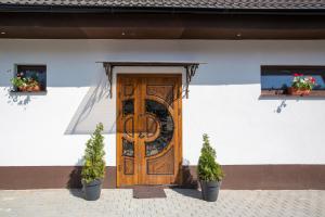 eine Holztür an einem Gebäude mit zwei Topfpflanzen in der Unterkunft Pension -Villa Vintage Room C 108 in Tomášikovo