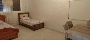 a room with two beds and a chalkboard at Appartement familial Nador Selouane in Selouane