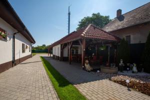 ein Gebäude mit einem Pavillon, unter dem Hunde sitzen in der Unterkunft Pension -Villa Vintage Room C 108 in Tomášikovo + 15 Fotos