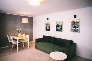 布加勒斯特Cotroceni Accommodations Upstairs的客厅里有一张绿色的沙发和一张桌子