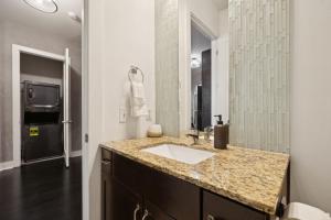 a bathroom with a sink and a mirror and a television at Neon Daes Amazing 1 Bedroom Near Vandy and Broadway in Nashville +35 photos