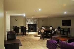 a living room with tables and chairs and a fireplace at Royal George Hotel in Birmingham +7 photos