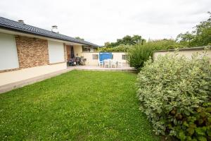 a backyard with green grass and a house at Le Luma - Maison 6 prs - Jardin - Ping-Pong in Noisiel