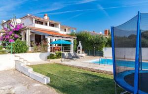 a villa with a swimming pool and a house at Holiday Home Krse V in Premantura