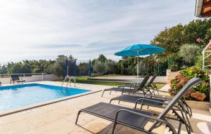 a patio with chairs and an umbrella and a pool at Holiday Home Krse V in Premantura