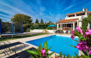 a swimming pool in a backyard with a house at Holiday Home Krse V in Premantura