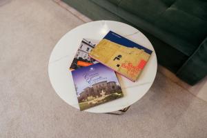 a white plate with books on a table at Cotroceni Accommodations Upstairs in Bucharest