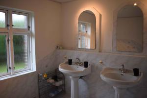 a bathroom with two sinks and a mirror at Villa In A Cozy Village In Southern Jutland in Tønder +8 photos