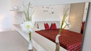 a room with a bed with red and white pillows at Comfort Apartments in Castelnuovo +41 photos