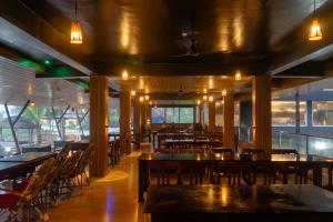 un restaurant avec des tables et des chaises en bois et des lumières dans l'établissement Palm TreeHeritage Beach Resort, à Varkala 49 autres photos